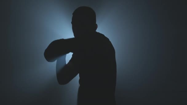 在低光体育馆进行拳击训练 运动员拳击在镜头 黑色烟熏背景的轮廓 Uhd 60Fps打拳时相机摇动的中型射击 — 图库视频影像