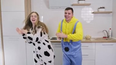 Mutfakta dans eden pijamalı mutlu genç çift. Yeni evliler geldi.