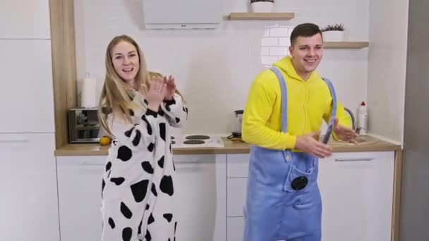 Two caucasian people wearing house clothing dancing and having fun at kitchen. — Stock Video