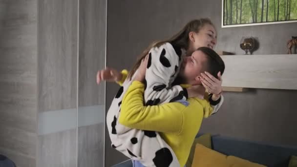 Młoda para w piżamie bawi się w domu. Szczęśliwa rodzina śmieje. — Wideo stockowe