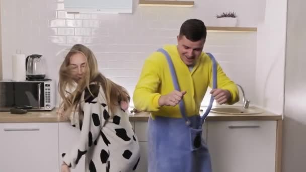 Mladý pár tančí v kuchyni v pyžamu a poslouchá hudbu ve 4k, Uhd — Stock video