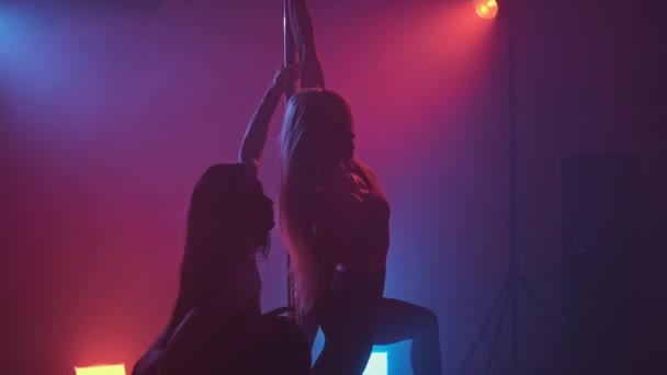 青と赤の煙でポールと暗いスタジオで2人のスリムなダンサー セクシーな体を持つエレガントなダンスの女の子 Uhdの中出し — ストック動画