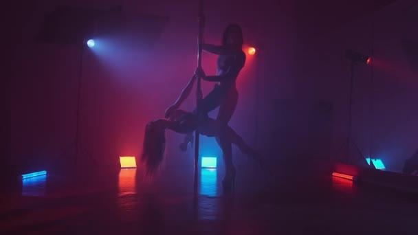 Mujeres sexy pole bailando en estudio oscuro con luces y humo. Humo rojo y azul — Vídeos de Stock