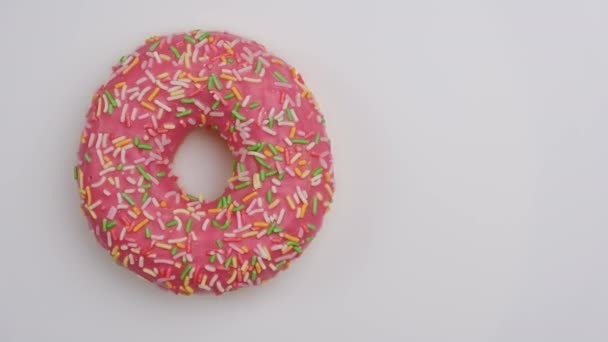 白色背景下旋转的色彩斑斓的新鲜甜甜圈的顶部视图. — 图库视频影像