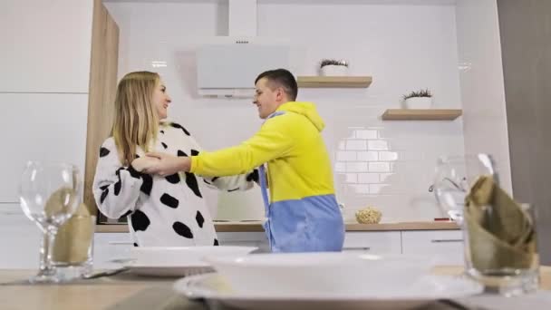 Feliz casal jovem dançando na cozinha vestindo pijama engraçado. Dança de família em 4K — Vídeo de Stock