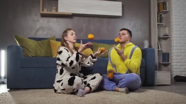 Young family juggling with mandarins in slow motion. Happiness and love concept — Stock Video