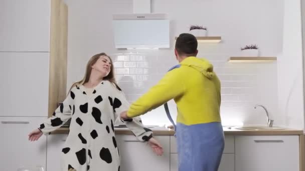 Jovem casal feliz família dançando rindo juntos na cozinha em pijama . — Vídeo de Stock