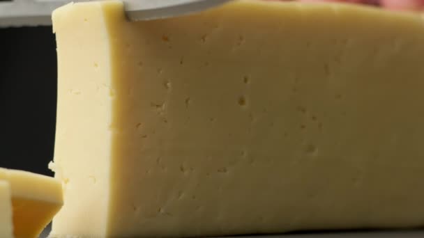 Alguien está cortando queso con un cuchillo especial en cámara lenta en 4K, UHD — Vídeos de Stock