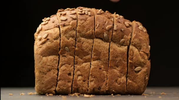 Människan tar en bit av det skurna brödet. Närbild av brunt ekologiskt bröd — Stockvideo