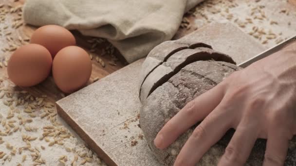Affettare il pane sul tagliere di legno. Pane integrale sul tagliere . — Video Stock