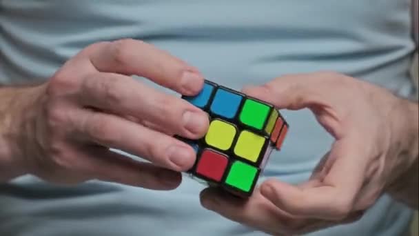 NUEVA YORK - 15 de marzo de 2020: el hombre resuelve el rompecabezas del cubo de Rubiks. Puzzle juego . — Vídeo de stock