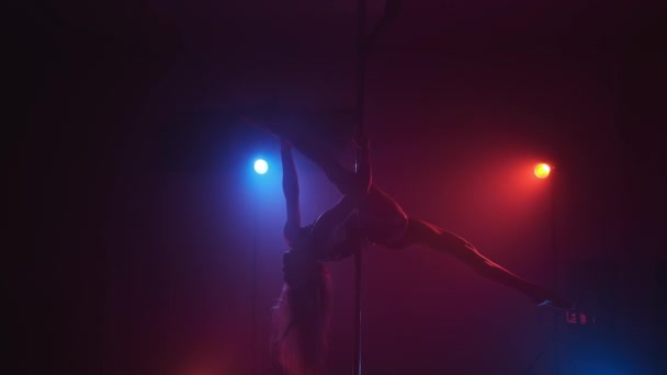Young woman dancing and spinning on pole. Female in smoky studio in 4K, UHD — Stock Video