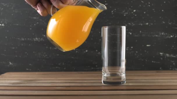 Apelsinjuice hälls i högt glas. Häll apelsinjuice i glas — Stockvideo