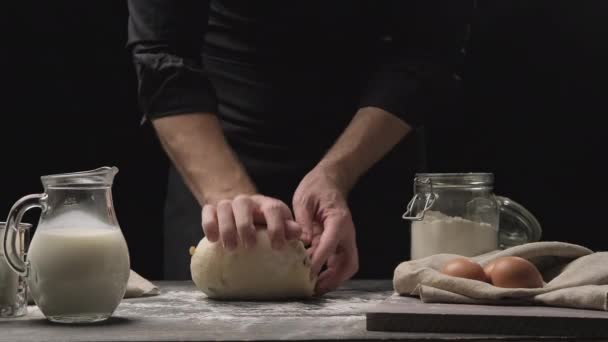 Пекарь руками месит тесто в муке на деревянном столе. Концепция выпечки в 4K, UHD — стоковое видео