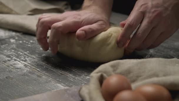 Mani maschili impastando la pasta in farina su tavolo di legno. Processo di fabbricazione . — Video Stock