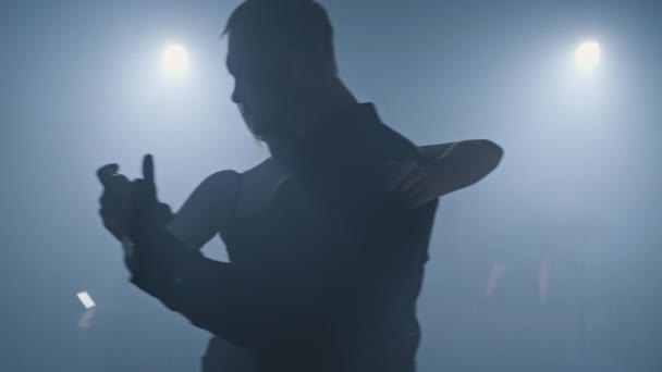 Silhuett av dansare i mörk studio med ljus. Professionella tangorörelser — Stockvideo
