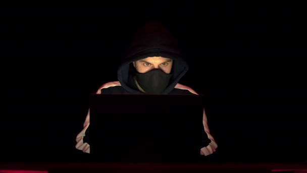 Hacker in hood and mask coding and programming using laptop. Concepto de ciberdelincuencia — Vídeos de Stock