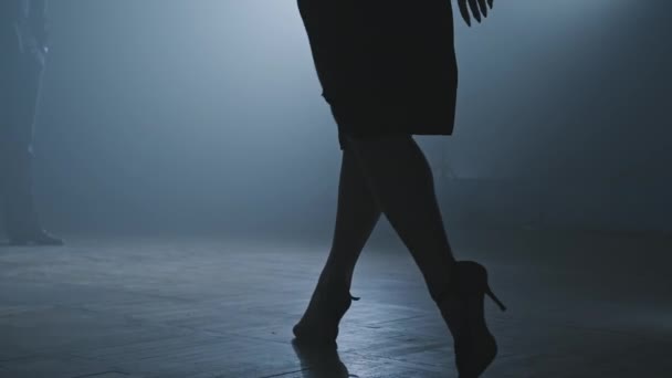 Legs of tango dancers in dark smoky studio. Woman goes to man. Legs on heels. — Stock Video