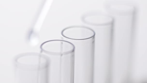 Teste de laboratório médico. Close-up da amostra de gotejamento da pipeta no tubo de teste. — Vídeo de Stock