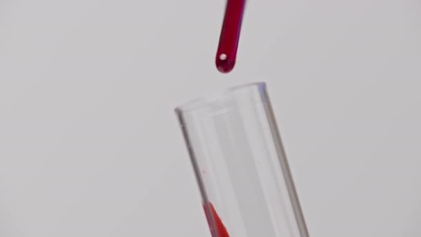 Macro van technicus druppelt bloed uit pipet in glazen buis voor test. 4K, UHD — Stockvideo