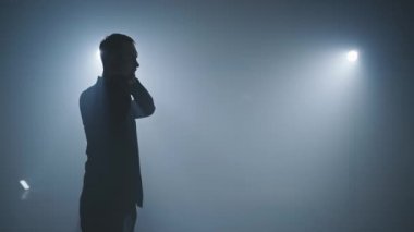 Erkek dansçı, gösteriden önce gömleğini düzeltir. Dans etmeye hazırlanan adam