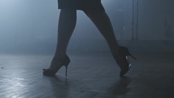 Legs of tango dancers in dark smoky studio. Woman goes to man. Legs on heels. — Stock Video