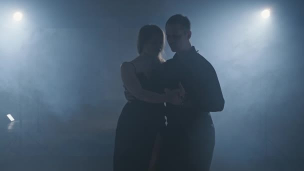 Silhouet van dansers in donkere studio met lichtjes. Vrouw en man dansen tango — Stockvideo