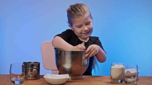 Cute little girl kneading dough for oat cookies with prunes. Girl having fun — Stock Video