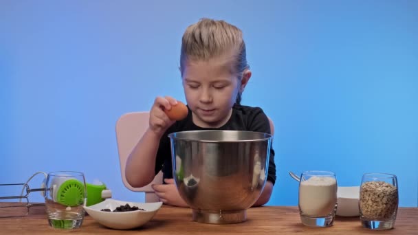 小女孩把鸡蛋分成金属碗.做燕麦饼干的女孩 — 图库视频影像