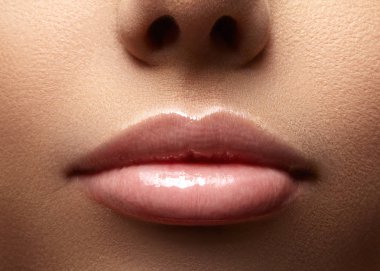 Yakın çekim güzel kadın dudakları parlak lipgloss makyaj ile. Temiz cilt mükemmel, taze dudak makyaj ışık. Güzel spa makro ihale pembe ruj ile vurdu. Spa ve kozmetik