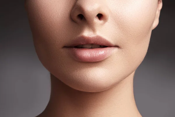 Close-up mooie vrouwelijke lippen met lipgloss lichte make-up. Perfect schone huid, lichte vers lip make-up. Mooie wellness macro geschoten met zacht roze lipgloss. Spa en cosmetica — Stockfoto