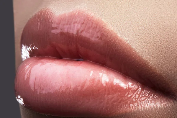 Close-up beautiful female lips with bright lipgloss makeup. Perfect clean skin, light fresh lip make-up. Beautiful spa macro shot with tender pink lip gloss. Spa and cosmetics — Stock Photo, Image