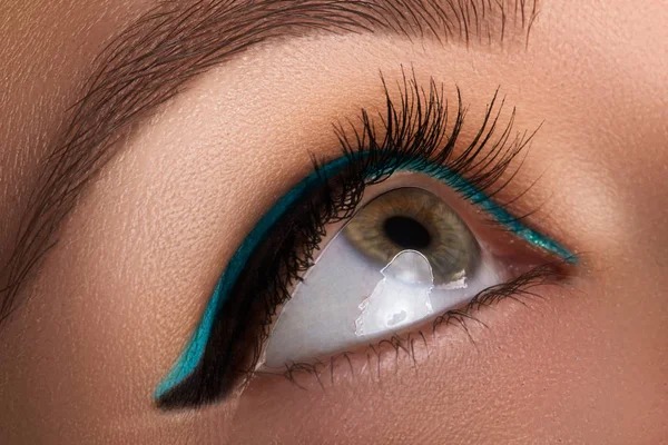 Nahaufnahme von weiblichen Augen. Frau mit blauem Eyeliner. Mode-Make-up mit perfekter Pfeile Form mit hellen Aquamarin Lidschatten Farbe. Kosmetik und Make-up — Stockfoto