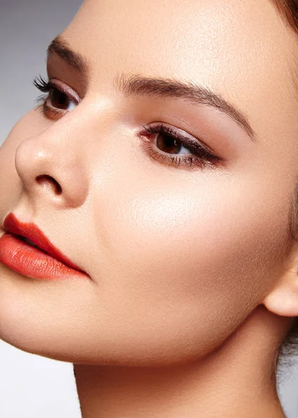 Hermosa modelo con maquillaje de moda. Retrato de cerca mujer sexy con glamour maquillaje brillo labial y maquillaje delineador de ojos negro. Tiro de celebrar el rostro, piel limpia, labios con lápiz labial rojo, cejas —  Fotos de Stock