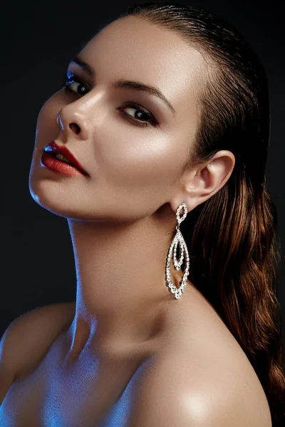 Mooie vrouw in luxe fashion oorbellen. Diamanten glimmende juwelen met brilliants. Sexy retro stijl portret. Model met glamour accessoires sieraden, mode make-up, schone glimmende huid en natte haren — Stockfoto