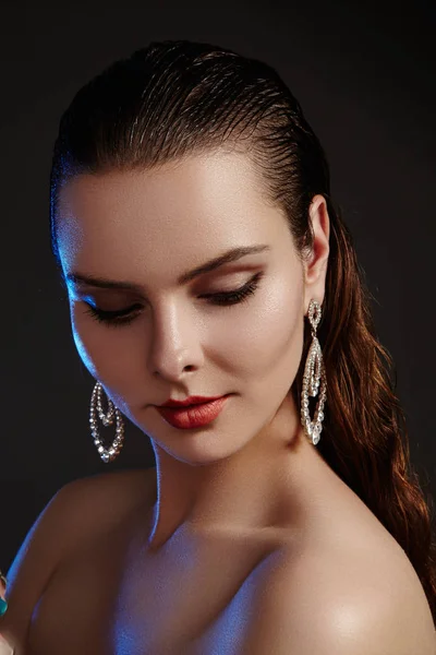 Belle femme dans les boucles d'oreilles de mode de luxe. Diamant bijoux brillants avec des brillants. Portrait de style rétro sexy. Modèle avec accessoires glamour bijoux, maquillage de mode, peau brillante propre et cheveux mouillés — Photo