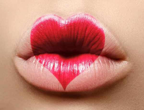 Cuore di San Valentino su belle labbra femminili. Dolce bacio. Amo il trucco per il giorno delle valntine. Carino il cuore a forma di simbolo d'amore. Festeggia il trucco delle labbra su macro shoot — Foto Stock