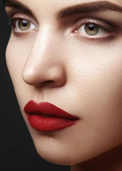 Piękny model z mody makijaż. Close-up portret sexy kobieta z seksowny makijaż ust połysk i czarny eyeliner makijaż. Strzał z okazji visage, czystą skórę, usta czerwone szminki, brwi — Zdjęcie stockowe