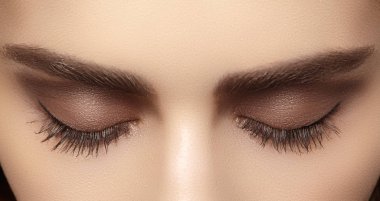 Kaşlar, kahverengi kaptırdın ve uzun kirpiklerini mükemmel şekli. Closeup makro moda dumanlı gözler sima vurdu