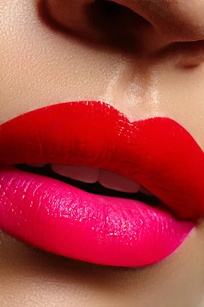 Cosméticos, maquilhagem. Batom brilhante nos lábios. Close-up de bela boca feminina com maquiagem labial vermelha e rosa. Parte da face — Fotografia de Stock