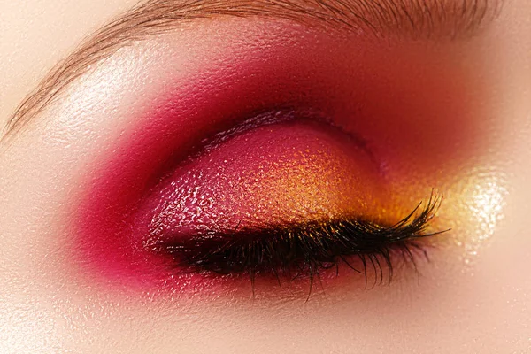 Closeup vrouwelijke oog met mode lichte make-up. Mooie glanzende goud, roze oogschaduw, nat glitter, zwarte eyeliner — Stockfoto