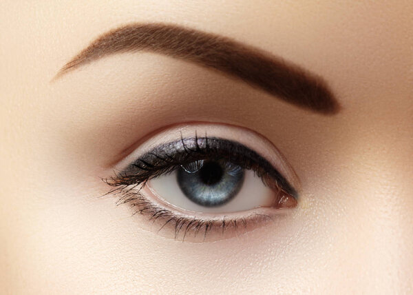 Крупный план Макро красивого женского глаза с идеальной формой бровей. Чистая кожа, модный натуральный макияж. Хорошее видение