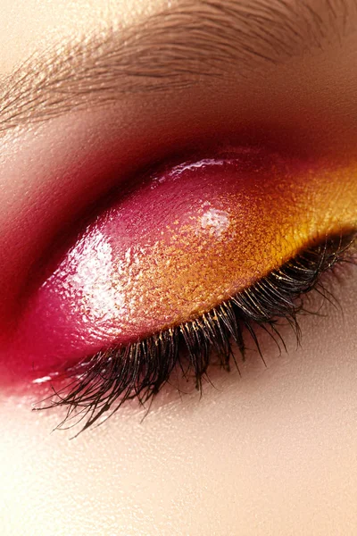 Closeup vrouwelijke oog met mooie mode lichte make-up. Mooie glanzende goud, roze oogschaduw, nat glitter — Stockfoto