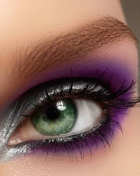 Closeup female eye with fashion bright make-up. Beautiful silver, purple eyeshadow, glitter, black eyeliner — Stock Photo, Image