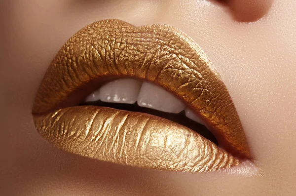 Hermoso primer plano con labios rellenos femeninos con maquillaje de color oro. Moda celebrar el maquillaje, brillo cosmético —  Fotos de Stock