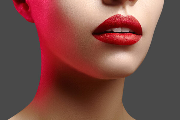 Cosmetics, makeup. Bright lipstick on lips. Closeup of beautiful female mouth with red lip makeup. Clean skin model