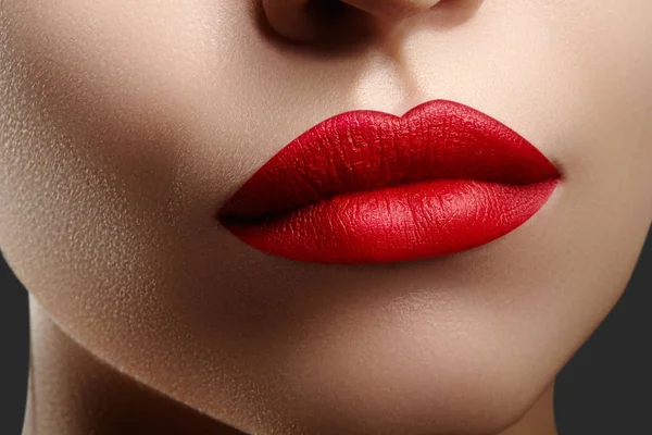 Kosmetika, make-up. Světlé rtěnky na rty. Detailní záběr na krásných ženských úst s červenými rty make-up. Čistá kůže model — Stock fotografie