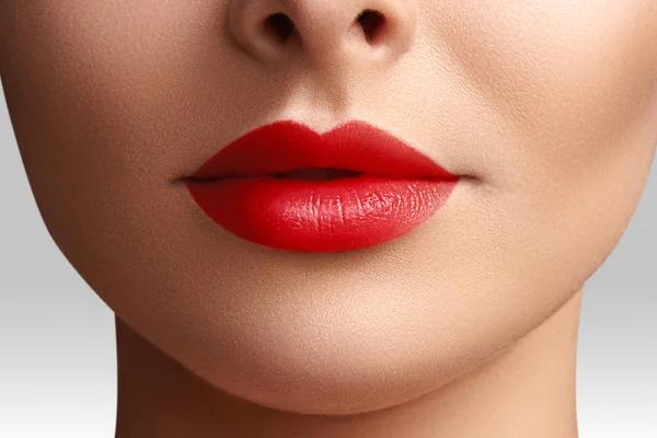 Cosmétiques, maquillage. Rouge à lèvres lumineux sur les lèvres. Gros plan de belle bouche féminine avec maquillage rouge à lèvres. Modèle de peau propre — Photo