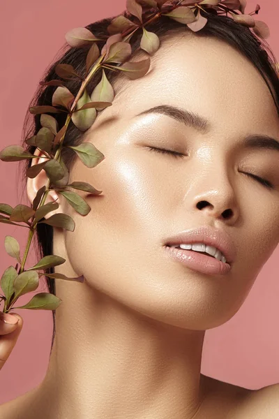 Belle femme asiatique avec maquillage frais quotidien. Vietnamienne beauté fille en spa traitement avec des feuilles vertes près du visage — Photo