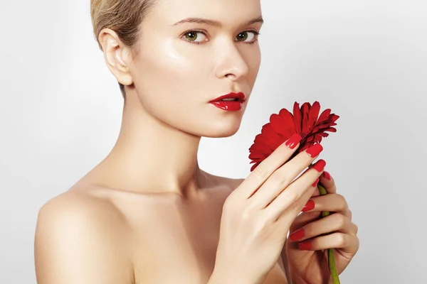 Крупный план красота фото сексуальная женщина с красными губами, помада и красивый красный цветок. Спа чистая кожа — стоковое фото